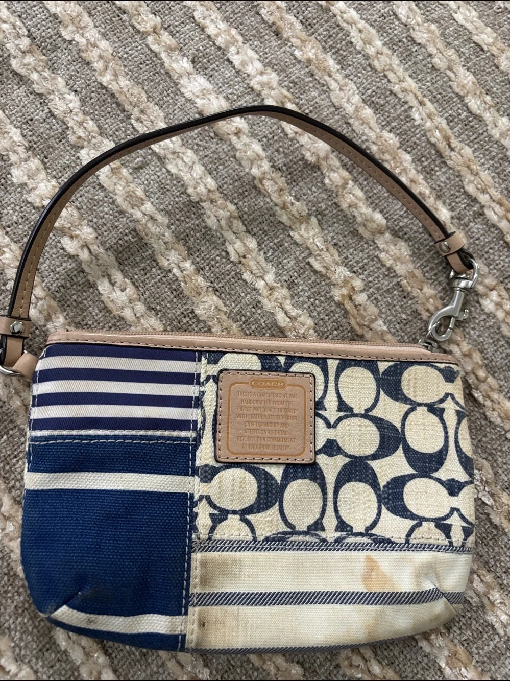 Coach wristlet featuring signature patchwork print in navy and cream